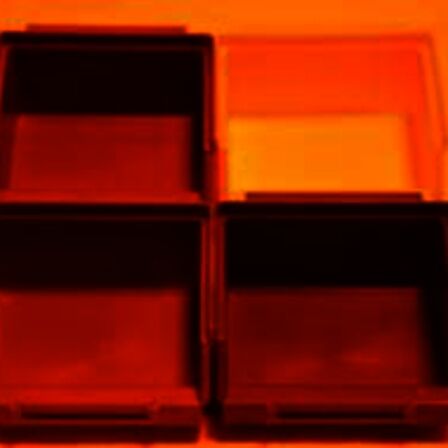 Gekleurde bakjes die verlicht worden met oranje licht, alles lijkt rood/oranje