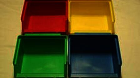 Bakjes van verschillende kleuren die verlicht worden met wit licht, alle kleuren zijn zichtbaar